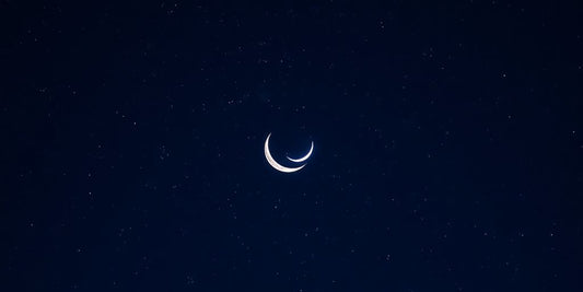 Cielo nocturno estrellado con luna creciente.