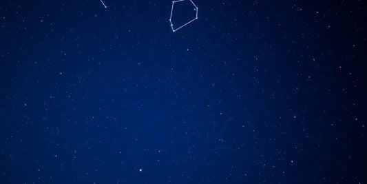 Cielo estrellado con constelaciones brillantes y fondo azul.
